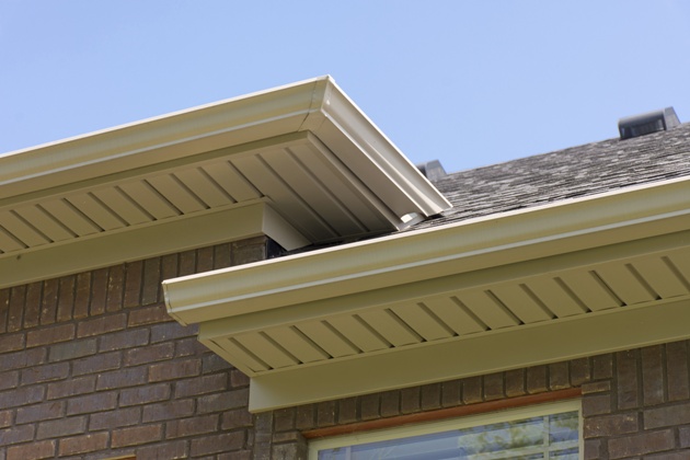 Roof showing gutters and soffit on the back of a brick house.